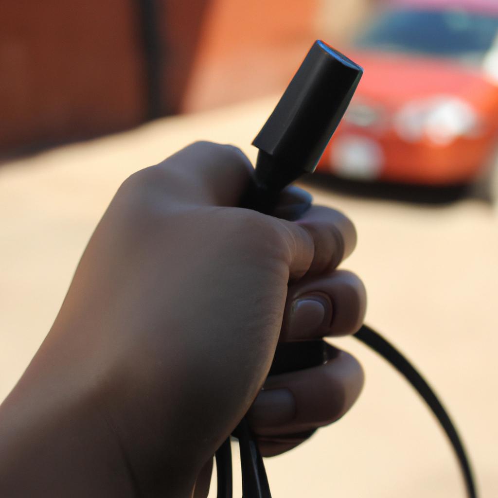 Person holding car charging cable